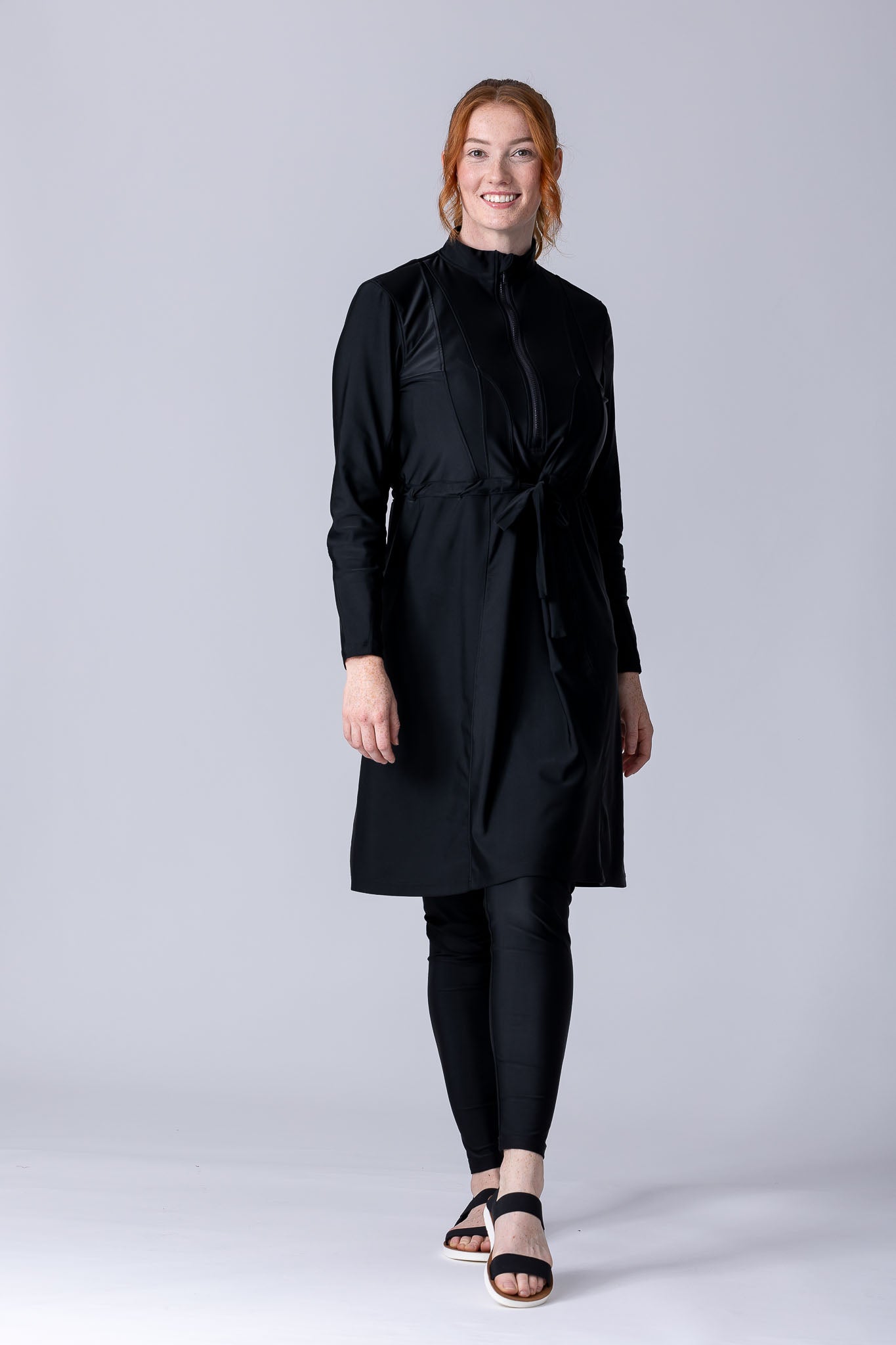 Modest midi swim tunic in black with front zipper, waist belt and UV proof swim fabric.