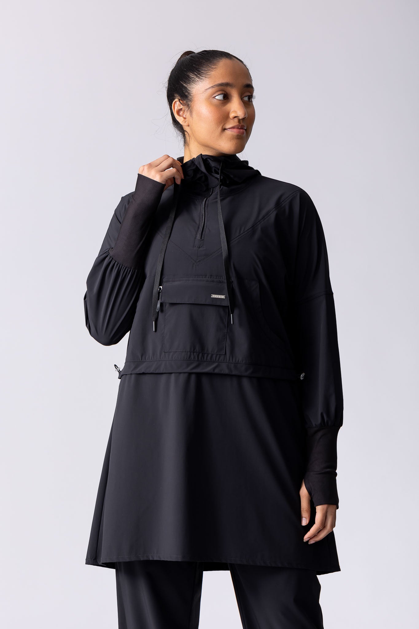 Light weight long line hoodie in black with adjustable waist, front pocket and large hood.