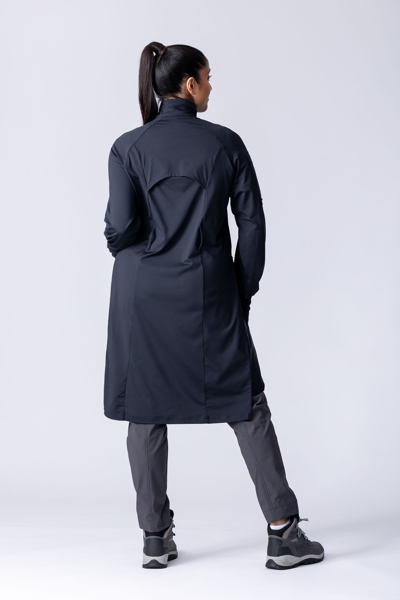 Long line tunic top in black. With front zipper, hidden side panels, back breathability panel and waist belt with buckle.