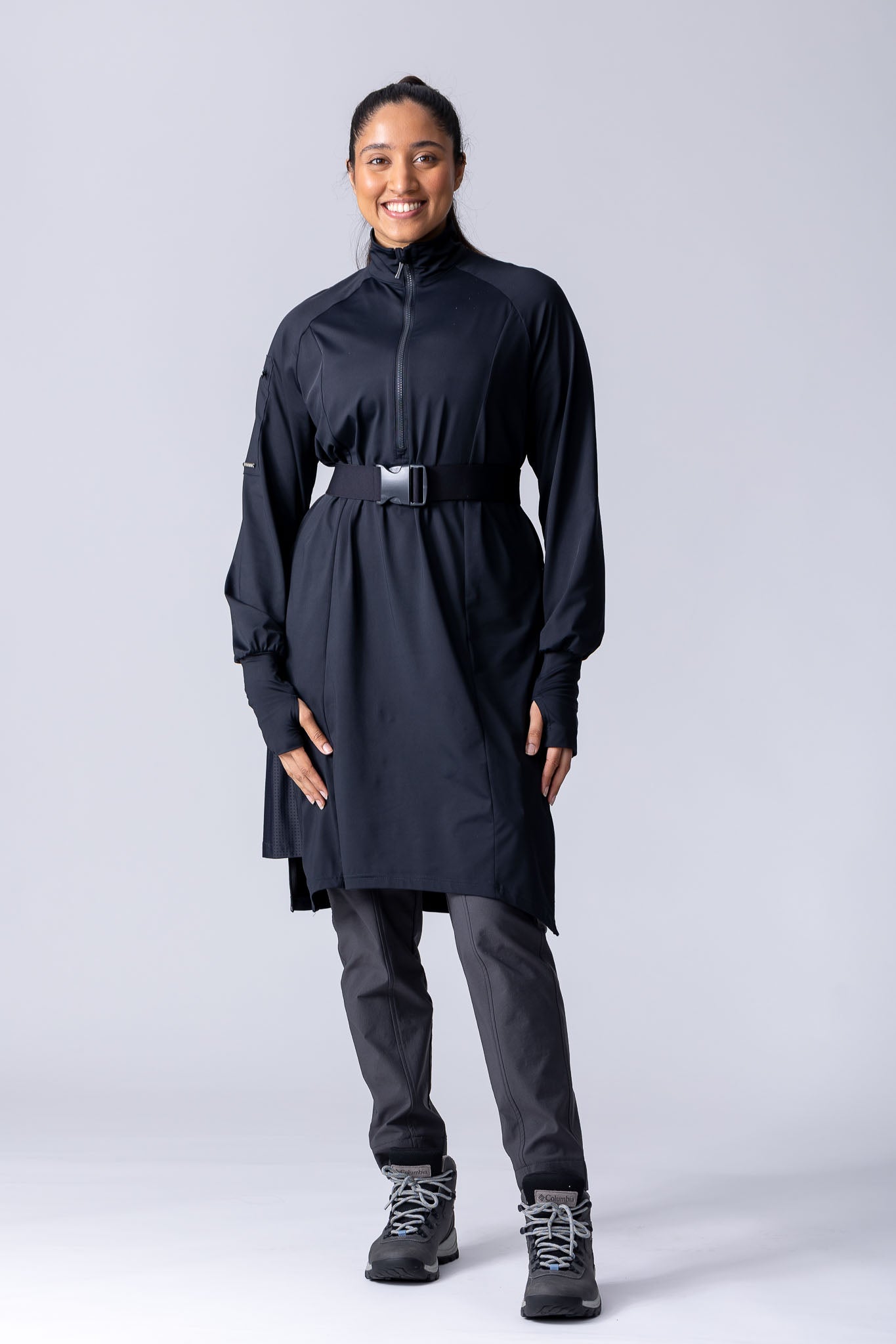 Long line tunic top in black. With front zipper, hidden side panels, back breathability panel and waist belt with buckle.