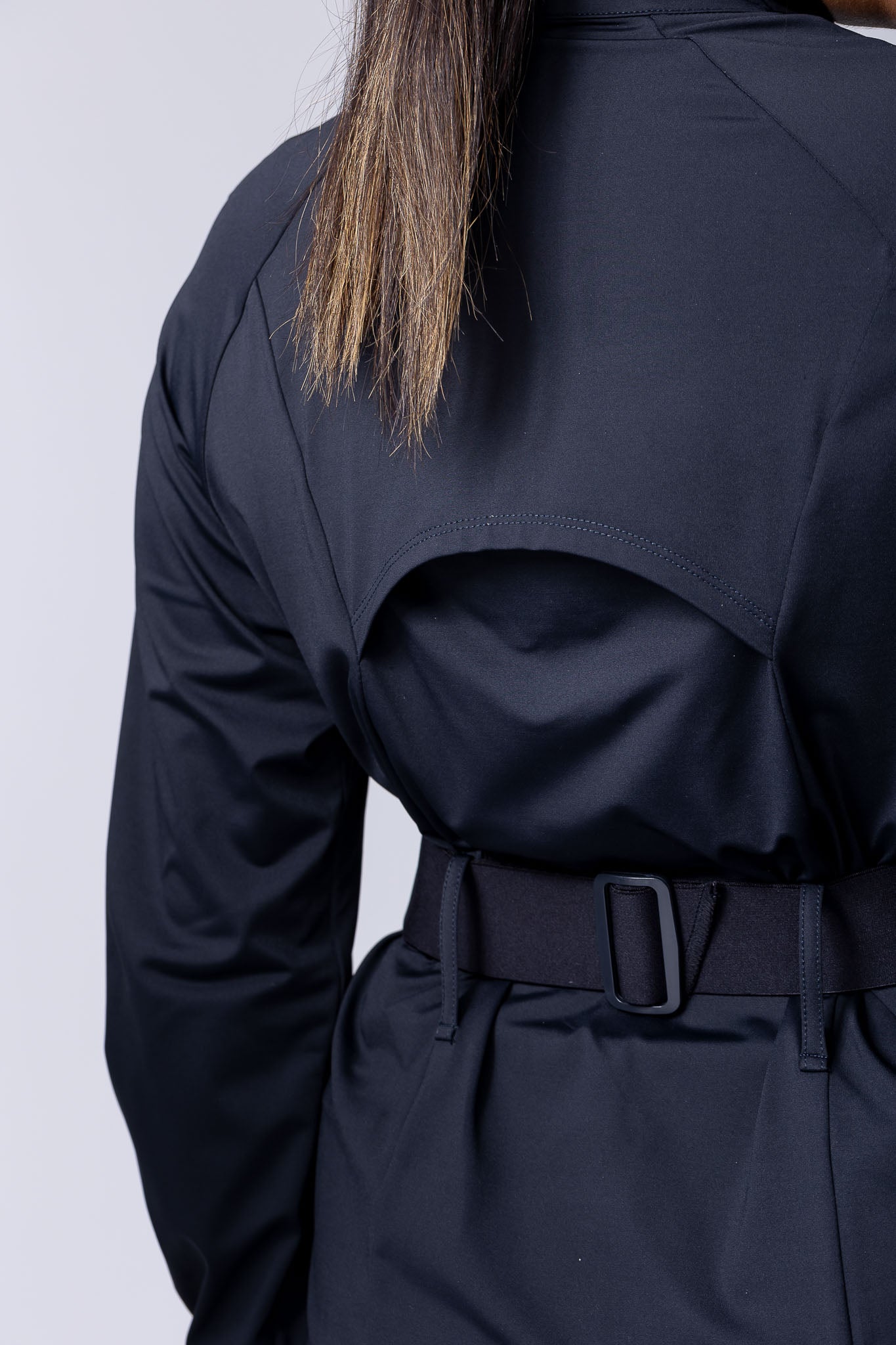 Long line tunic top in black. With front zipper, hidden side panels, back breathability panel and waist belt with buckle.