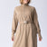 Long line tunic top in beige. With front zipper, hidden side panels, back breathability panel and waist belt with buckle.