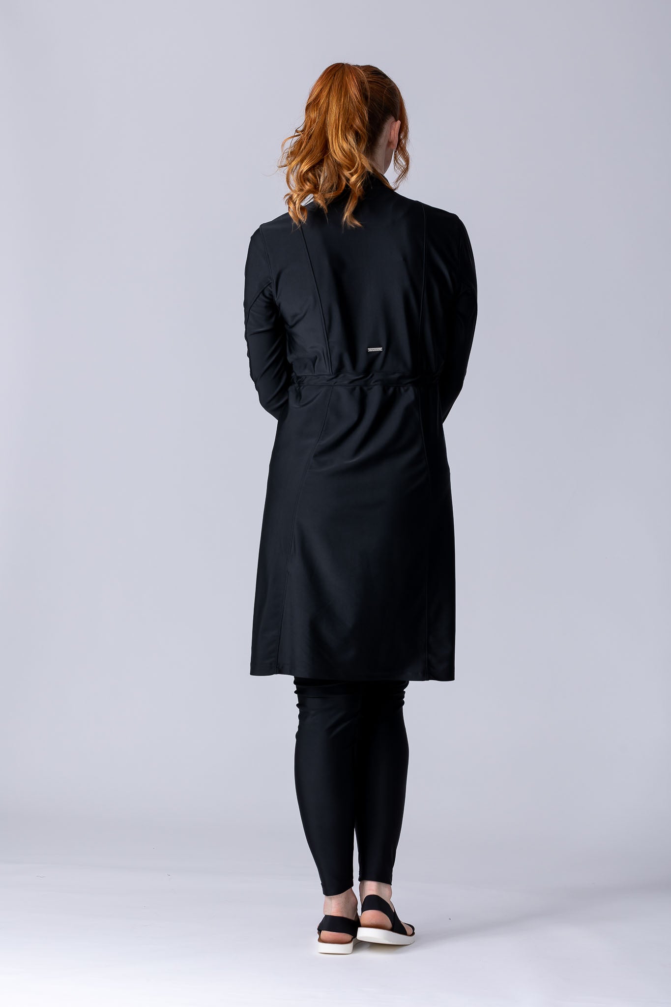 Modest midi swim tunic in black with front zipper, waist belt and UV proof swim fabric.