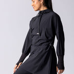Light weight long line hoodie in black with adjustable waist, front pocket and large hood.