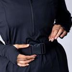Long line tunic top in black. With front zipper, hidden side panels, back breathability panel and waist belt with buckle.